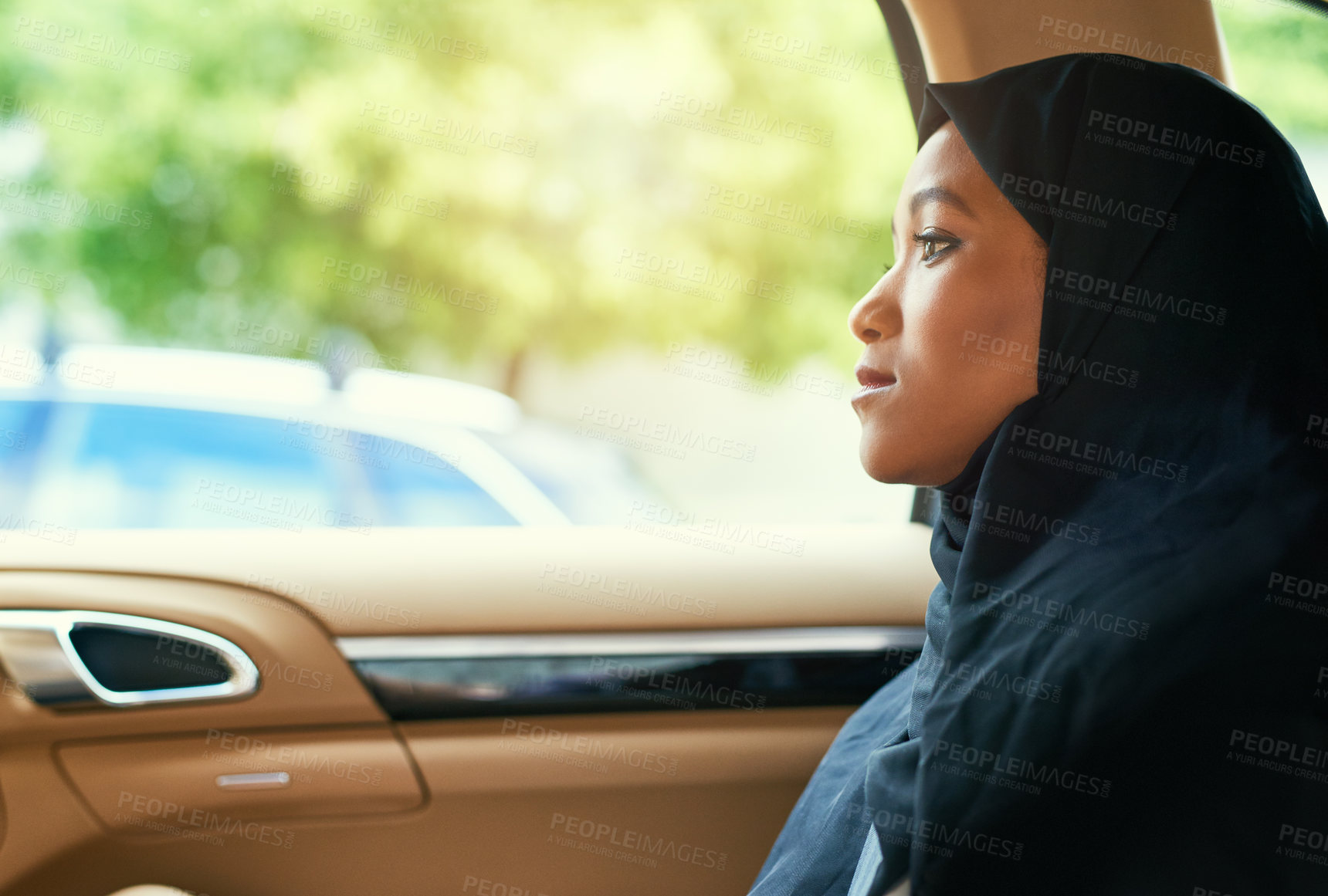 Buy stock photo Shot of a confident young businesswoman seated in the backseat of a car while driving to work during the day
