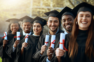 Buy stock photo Portrait of a group of young students holding their diplomas on graduation day