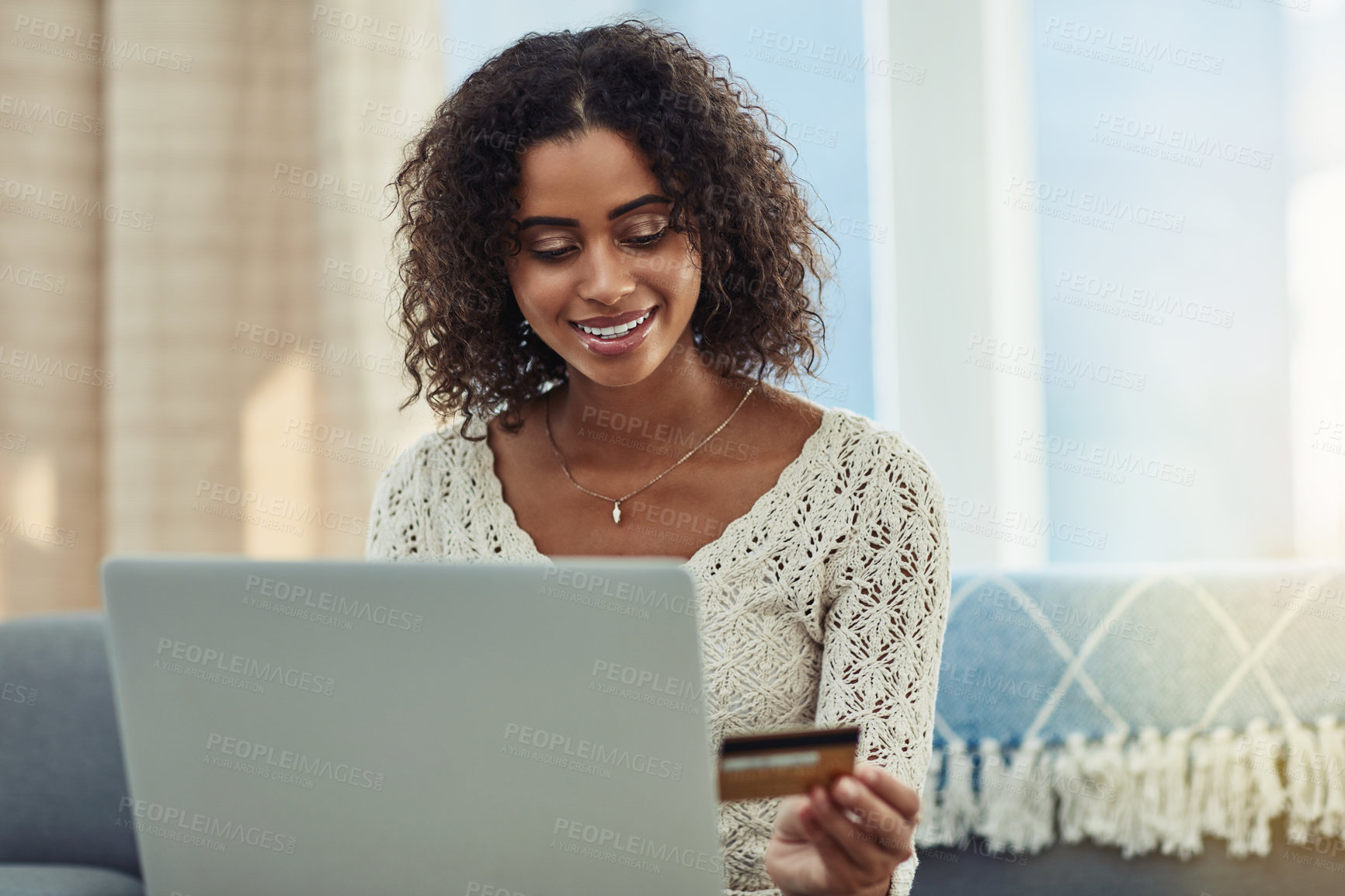 Buy stock photo Shot of an attractive young woman making payments online with a credit card at home