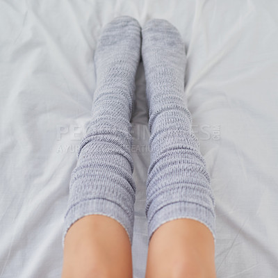 Buy stock photo Cropped shot of a woman wearing grey socks in bed