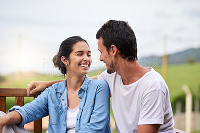 Buy stock photo Happy couple, relax and laughing with love on bench for date, holiday or outdoor weekend in countryside. Young, man and woman with smile in joy for romance, relationship or morning together on porch