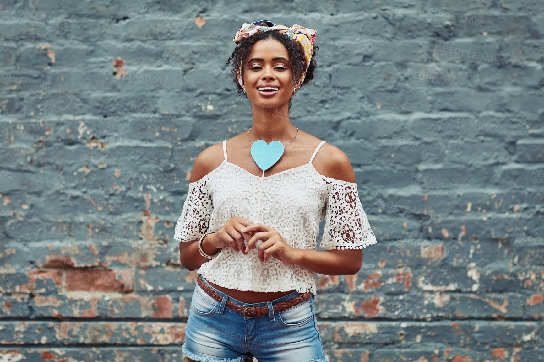 Buy stock photo Cropped shot of an attractive  young woman posing against a brick wall outside