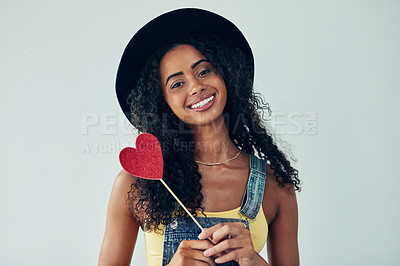 Buy stock photo Woman, portrait and studio with heart paper, confident and romance emoji by white background. Female person, fashion vote and icon for kindness or support, smile and symbol for feedback in Brazil