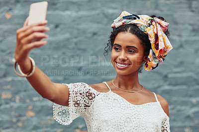 Buy stock photo Cropped shot of an attractive young woman taking a selfie against a brick wall outside