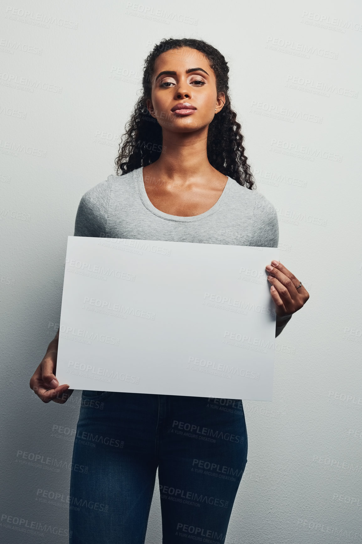 Buy stock photo Studio shot of an attractive young woman holding a blank placard against a grey background