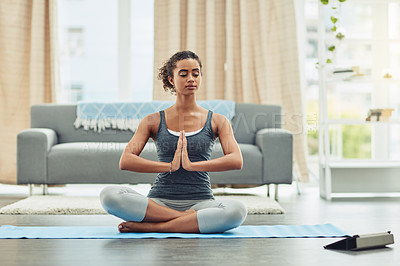 Buy stock photo Shot of an attractive young woman practicing yoga at home
