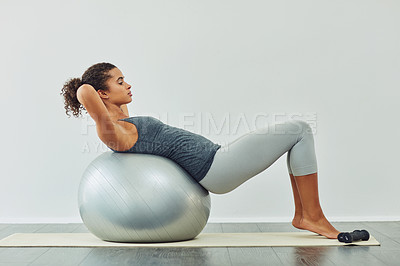 Buy stock photo Studio shot of an attractive young woman working out against a grey background