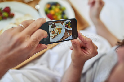 Buy stock photo PoV shot of an unrecognizable couple taking a photo of their breakfast that they're having in bed during morning hours