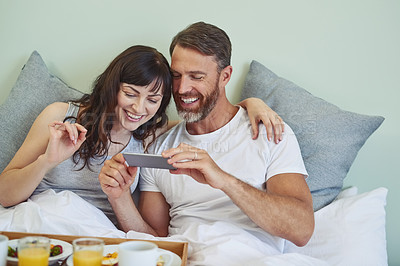 Buy stock photo Couple, happy and photography with fruit in bedroom, bed and breakfast for rental on honeymoon vacation with love. Man, woman and together in morning with picture, memory and commitment with care.