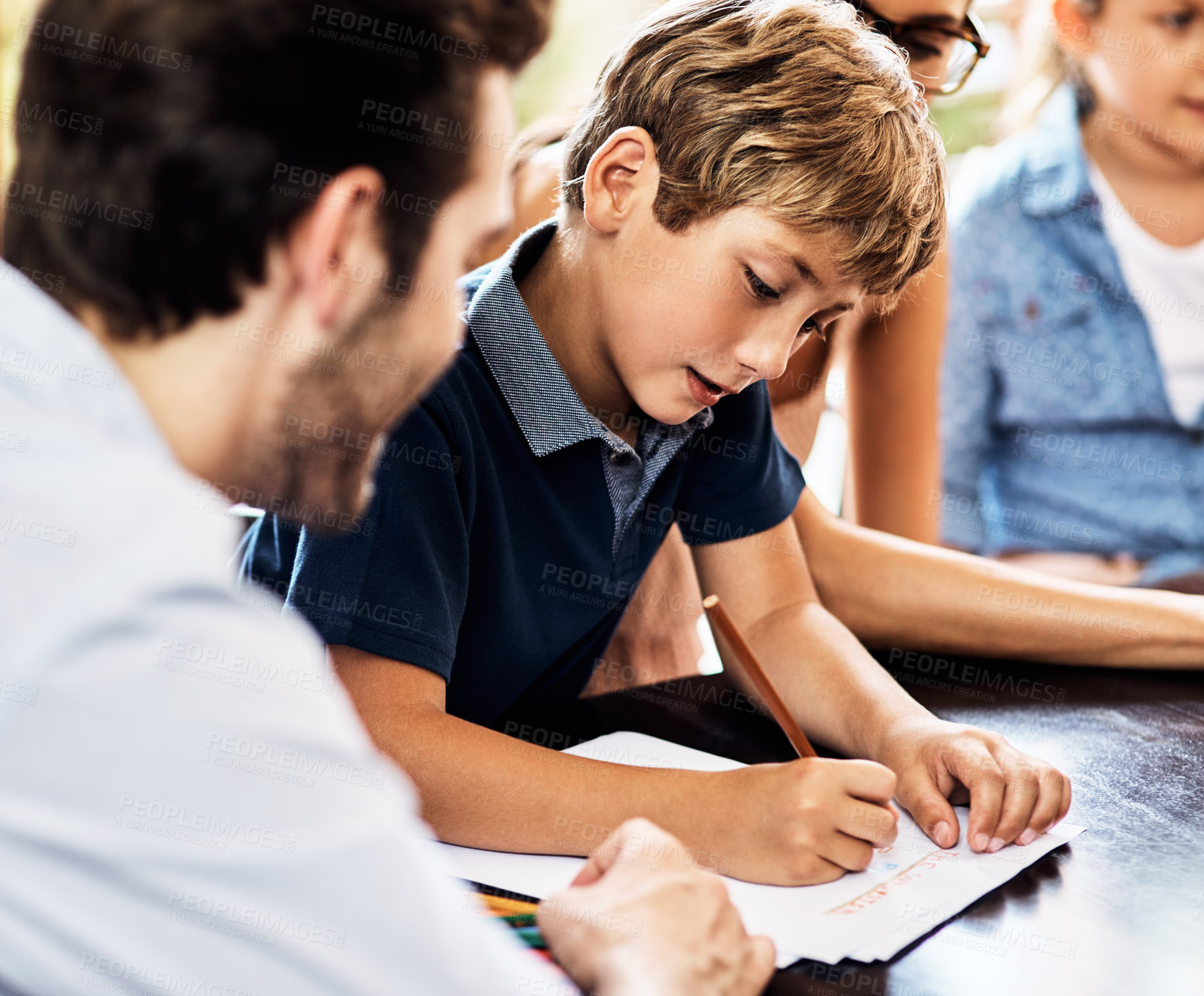 Buy stock photo Shot of a little boy doing his homework with the help of his father