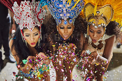 Buy stock photo Shot of samba dancers blowing confetti from their hands while performing in a carnival
