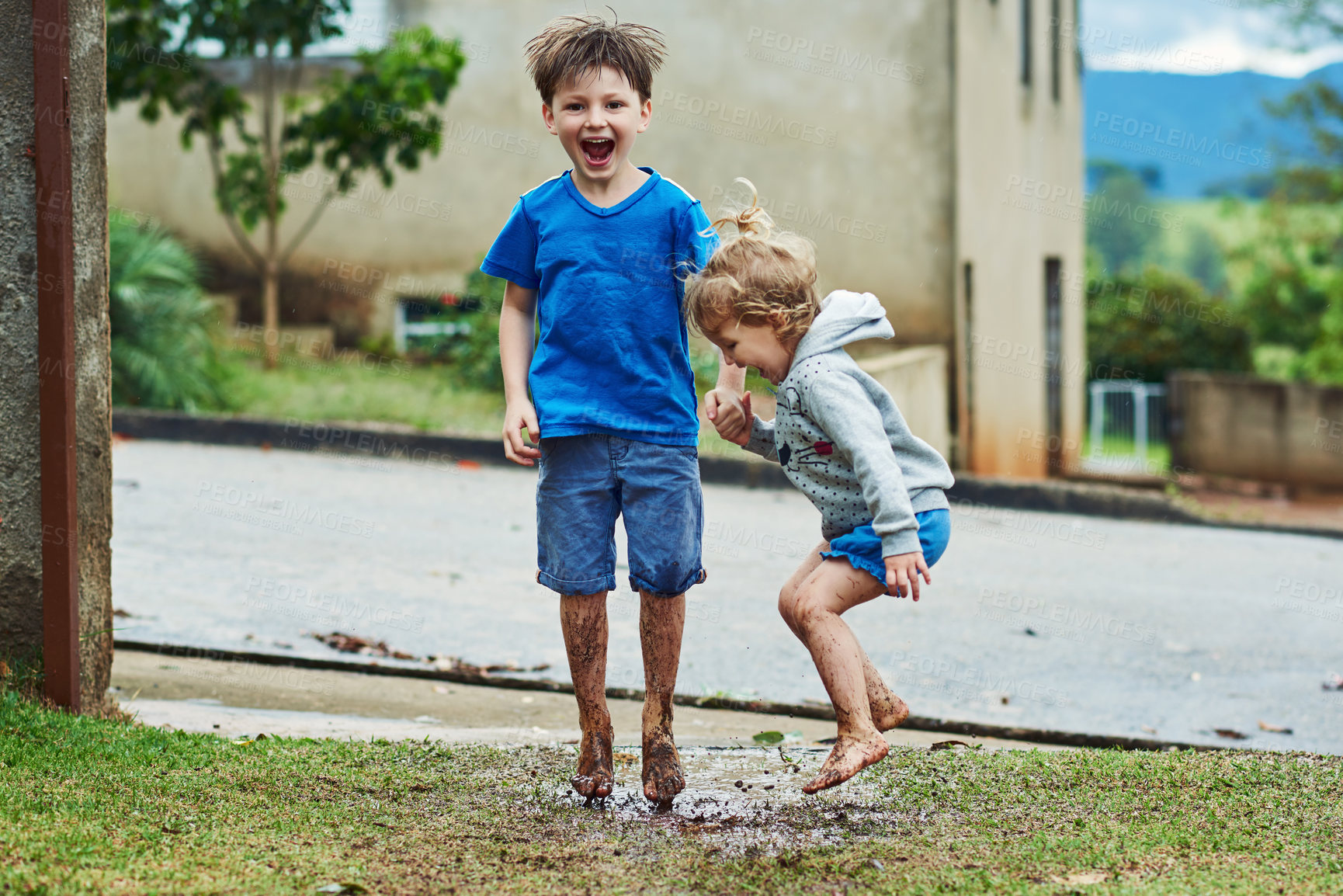 Buy stock photo Boy, portrait and girl playful in mud outdoor on rainy day, happiness and embracing mess for childhood fun. Puddle, children and jump in wet sand or dirt, physical activity and holding hands.