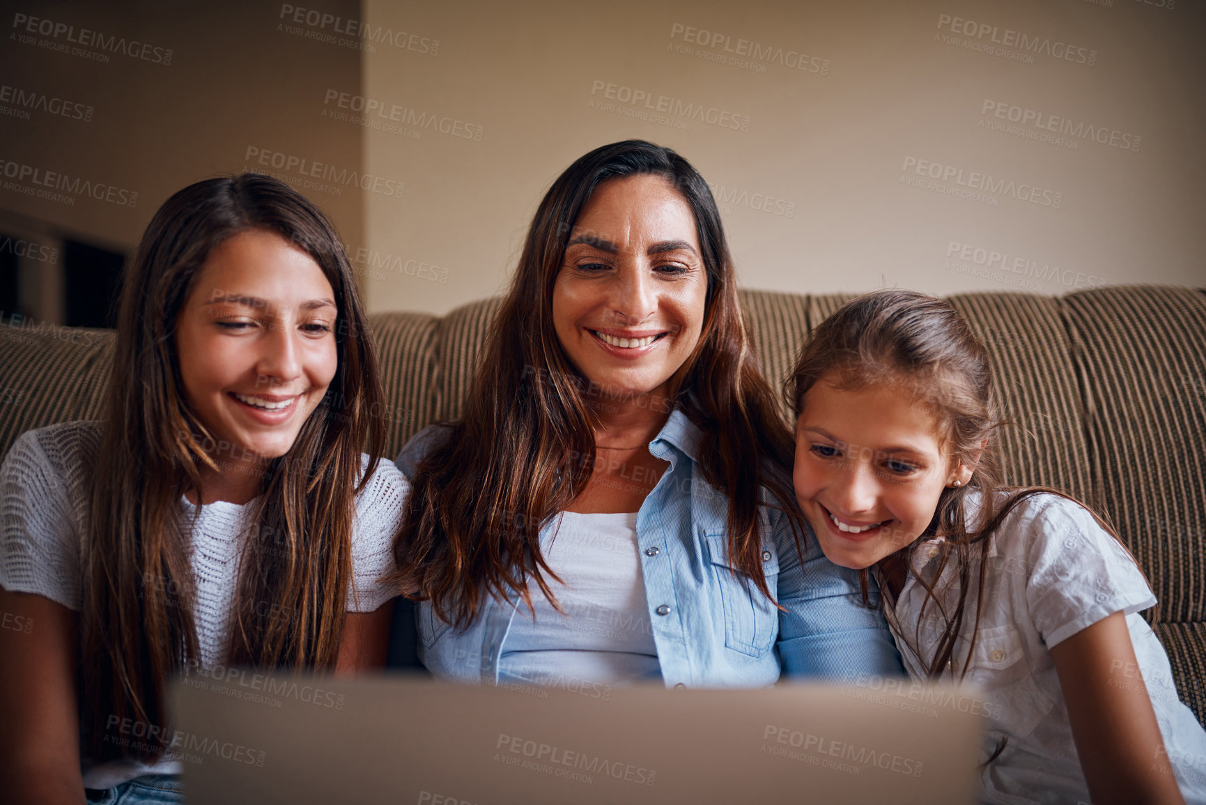 Buy stock photo Cropped shot of an attractive mother watching movies on a laptop with her two daughters at home