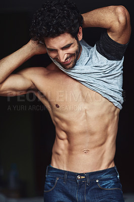 Buy stock photo Cropped shot of a handsome young man undressing at home