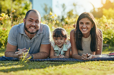 Buy stock photo Shot of an adorable little girl and her parents spending quality time together in the park