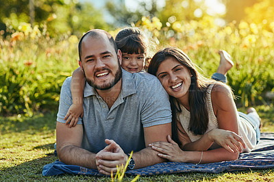Buy stock photo Shot of an adorable little girl and her parents spending quality time together in the park