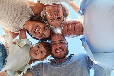 Buy stock photo Low angle portrait of a happy three generation family huddled together outdoors
