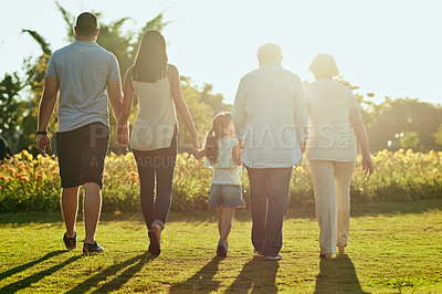 Buy stock photo Rearview shot of a family going for a walk together in the park
