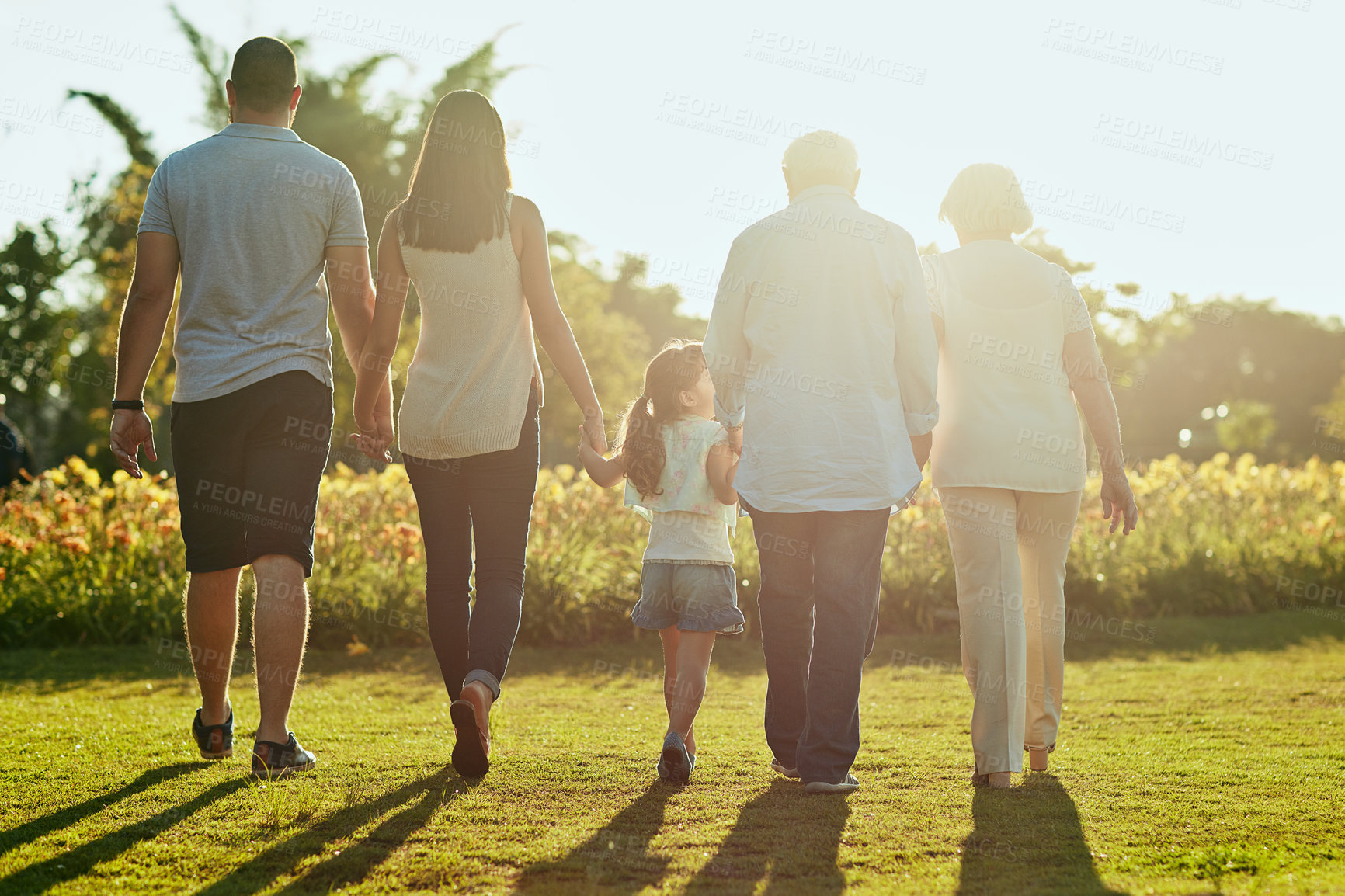 Buy stock photo Rearview shot of a family going for a walk together in the park