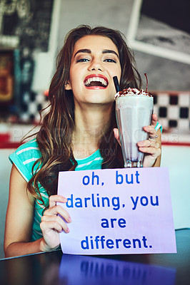 Buy stock photo Cropped shot of an attractive young woman holding up a sign while enjoying a milkshake in a retro diner