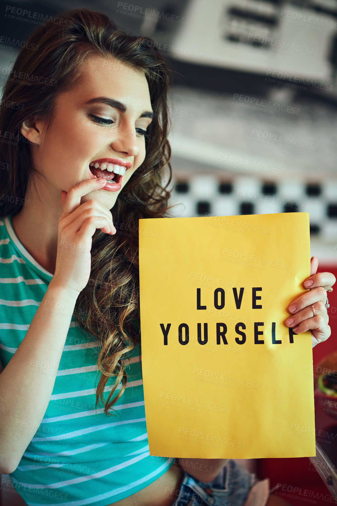 Buy stock photo Cropped shot of an attractive young woman holding up a sign in a retro diner