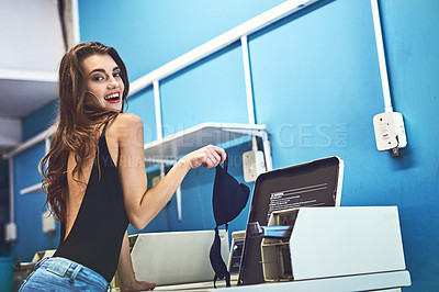 Buy stock photo Portrait of a attractive young woman doing her washing inside of a laundry room during the day