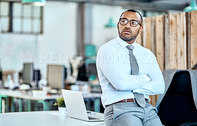 Buy stock photo Shot of a young businessman looking thoughtful while standing in an office