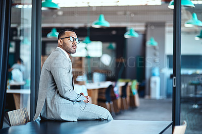 Buy stock photo Shot of a young businessman looking thoughtful in an office