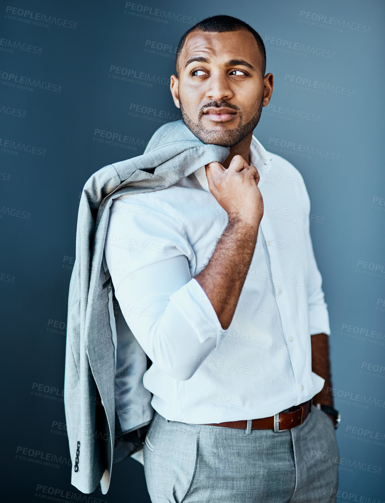 Buy stock photo Studio shot of a young businessman standing against a grey background