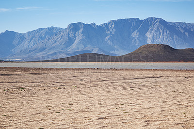 Buy stock photo Shot of a desolate landscape during the day with a small dried out dam in the middle