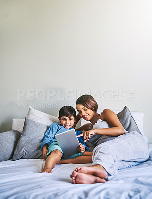 Buy stock photo Full length shot of an adorable little boy and his pregnant mother using a laptop while relaxing on her bed