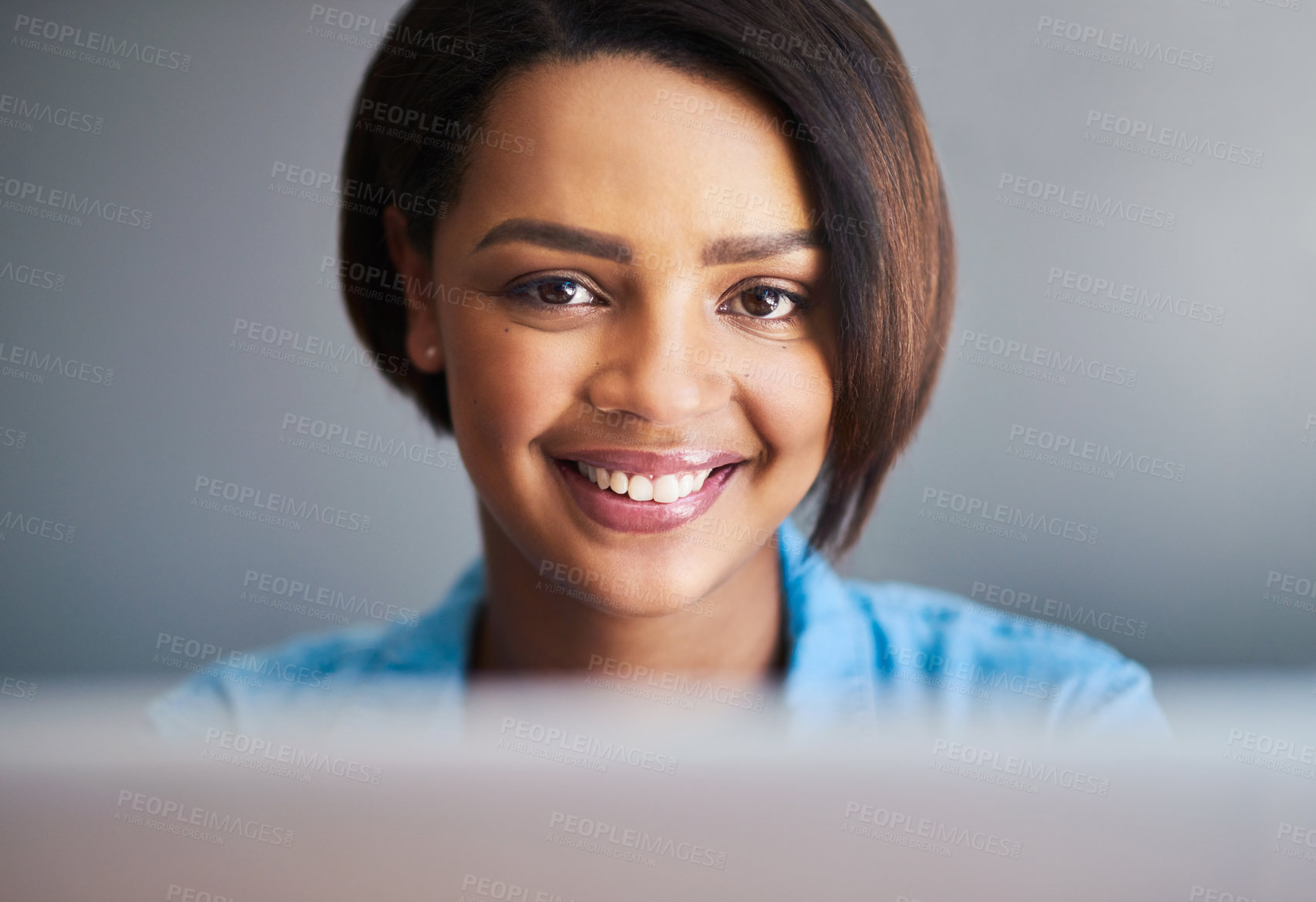Buy stock photo Shot of an attractive young woman using a laptop against a gray background