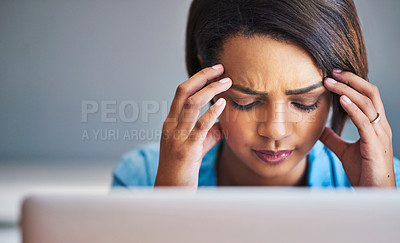 Buy stock photo Shot of an attractive young woman experiencing stress while using a laptop at home