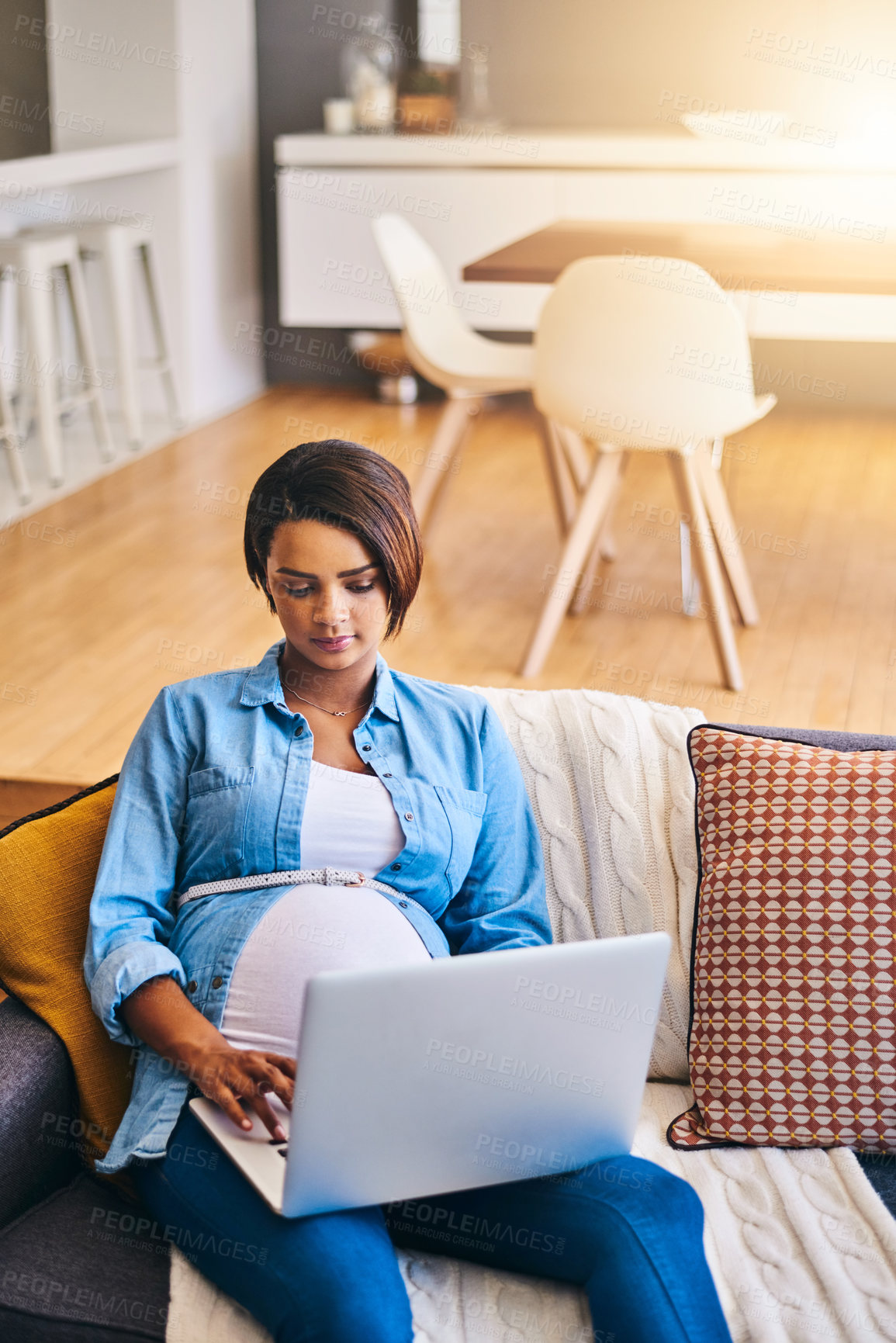 Buy stock photo Shot of a pregnant young woman using her laptop at home
