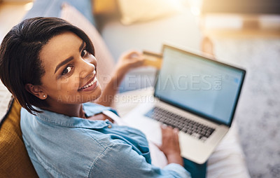 Buy stock photo Shot of a pregnant young woman using a laptop and credit card on the sofa at home