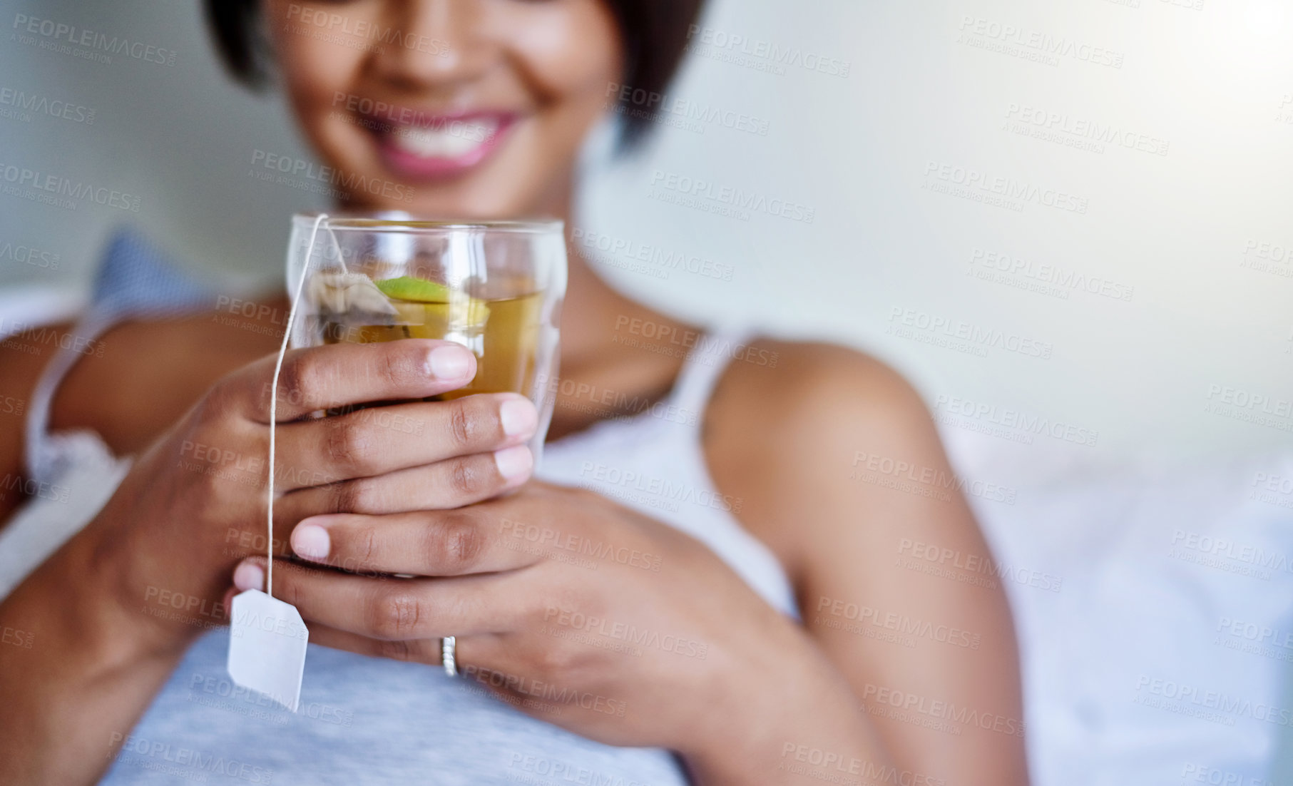 Buy stock photo Cropped shot of a young woman relaxing at home with a glass of tea