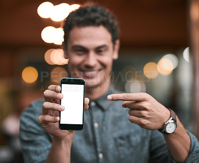 Buy stock photo Shot of a confident young man holding up a cellphone to the camera while standing inside of a beer brewery during the day
