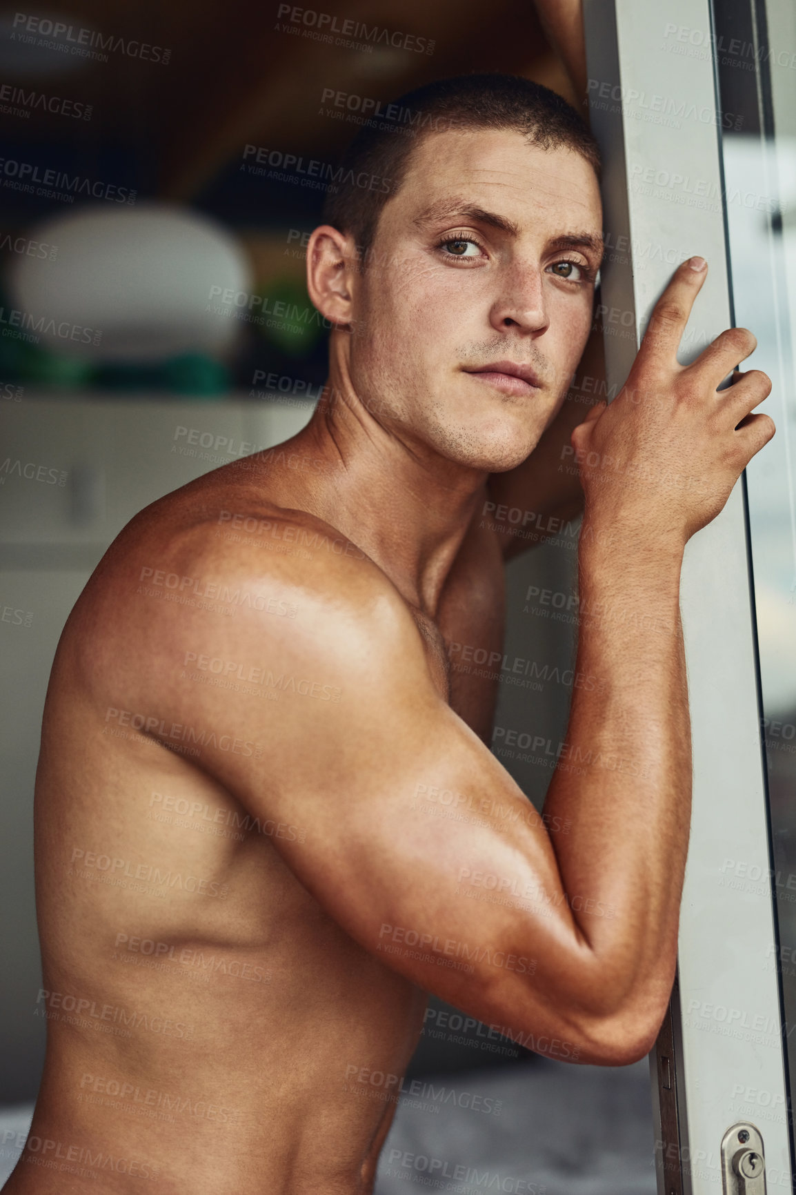 Buy stock photo Portrait of a confident young shirtless man leaning against a doorway in the kitchen at home