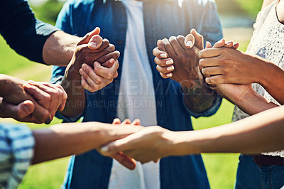 Buy stock photo Closeup shot of an unrecognizable group of people holding hands outdoors