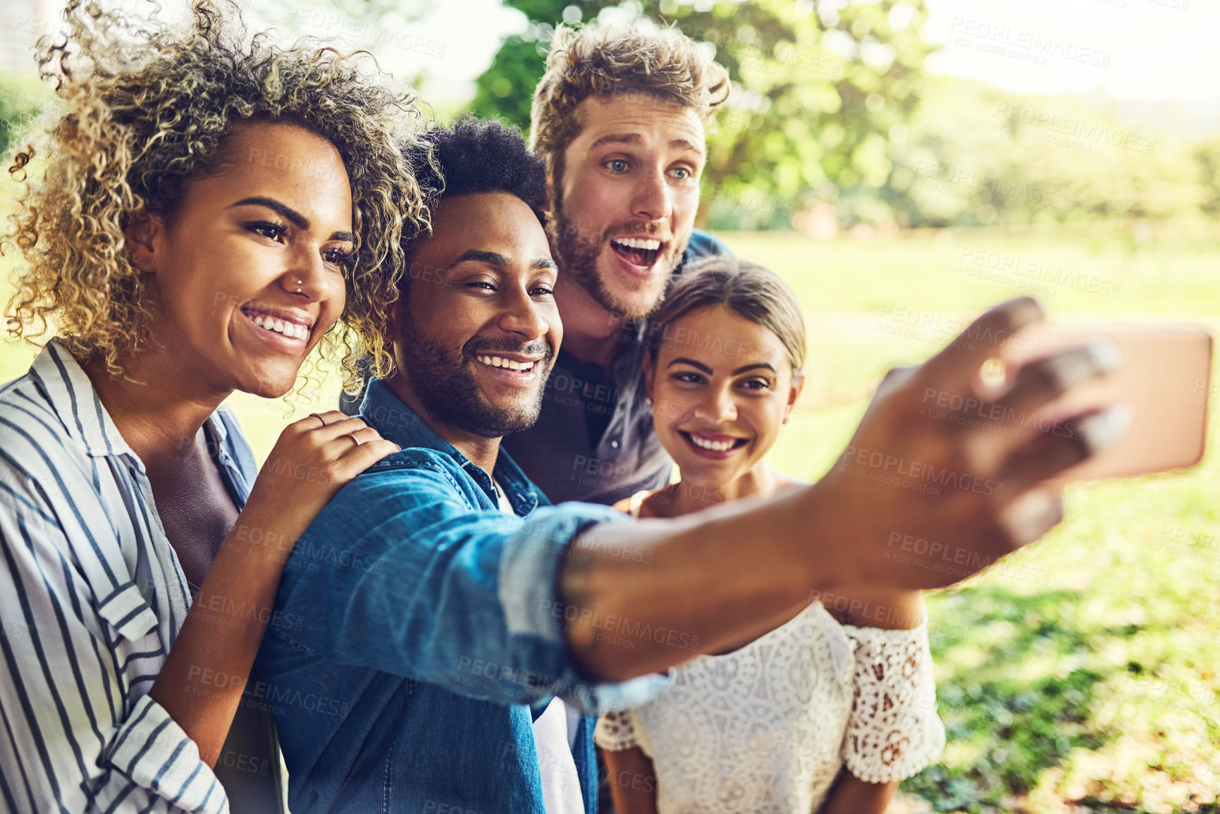 Buy stock photo Shot of a group of friends taking a selfie together outdoors