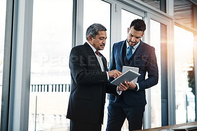 Buy stock photo Cropped shot of colleagues using a tablet in a modern office