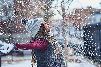 Buy stock photo Shot of a happy young woman throwing snow on a wintery day outdoors