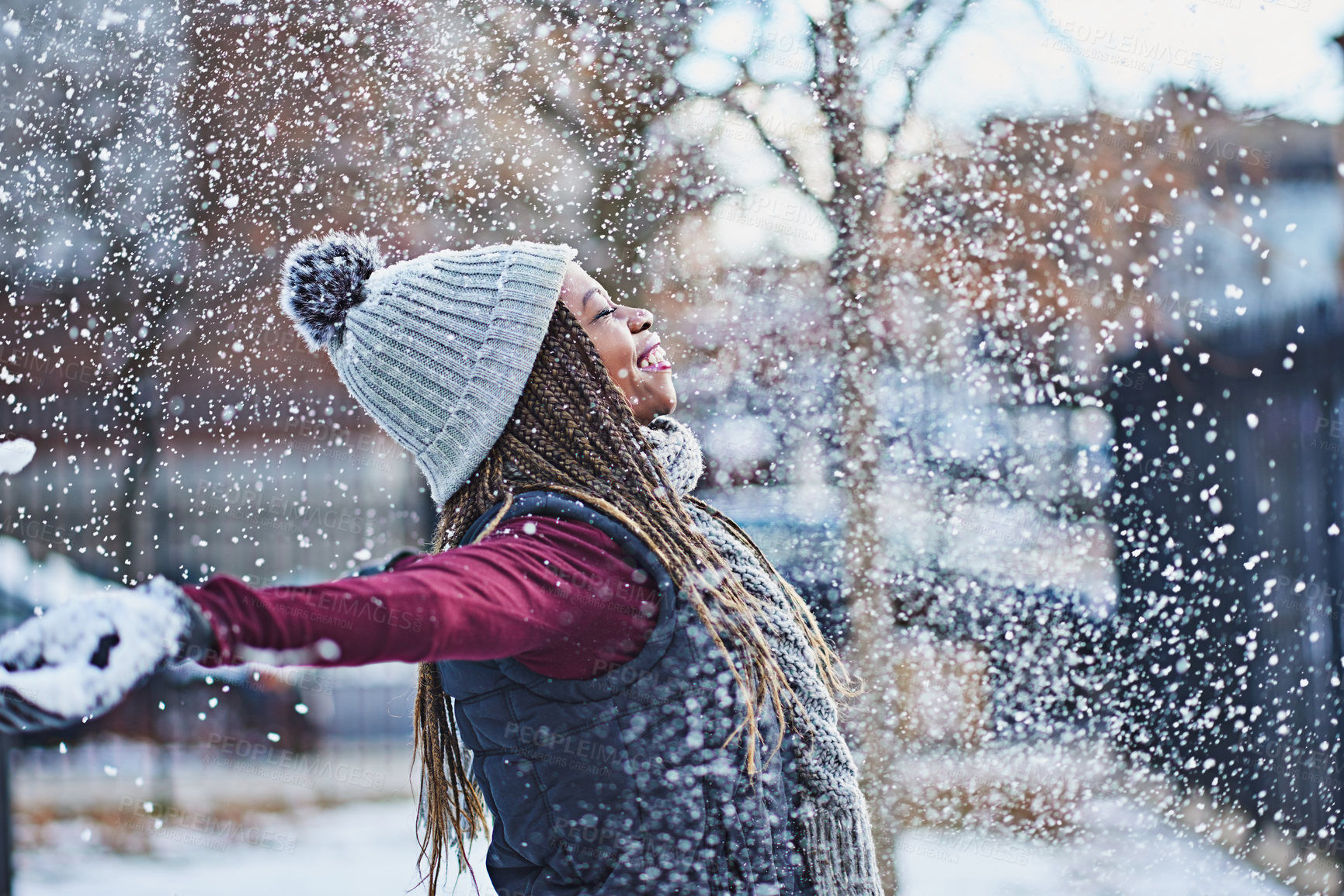 Buy stock photo Shot of a happy young woman throwing snow on a wintery day outdoors