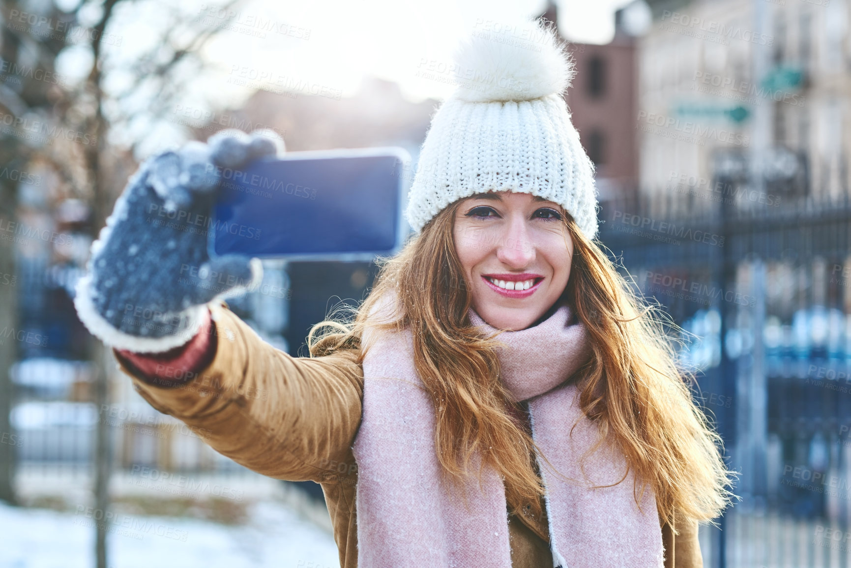 Buy stock photo Shot of an attractive young woman taking a selfie in the snow outside