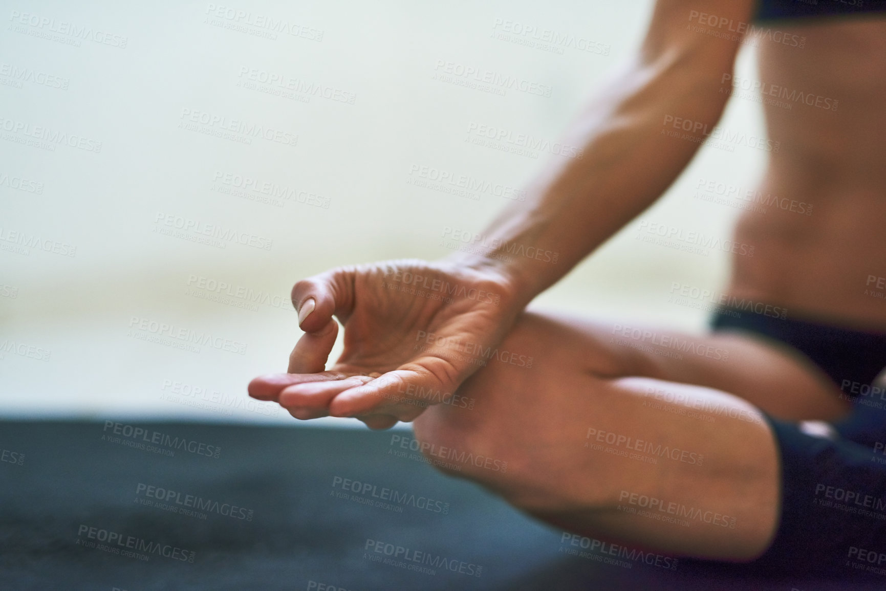 Buy stock photo Cropped shot of an unrecognizable young female athlete meditating at home