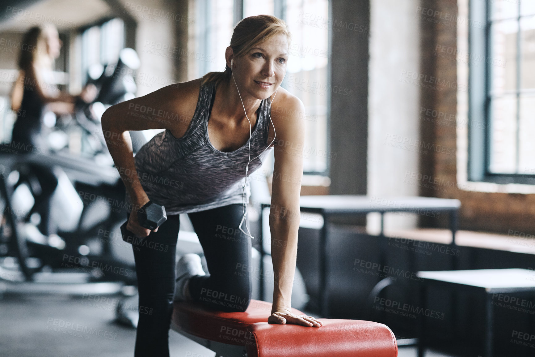Buy stock photo Shot of a mature woman lifting weights at the gym