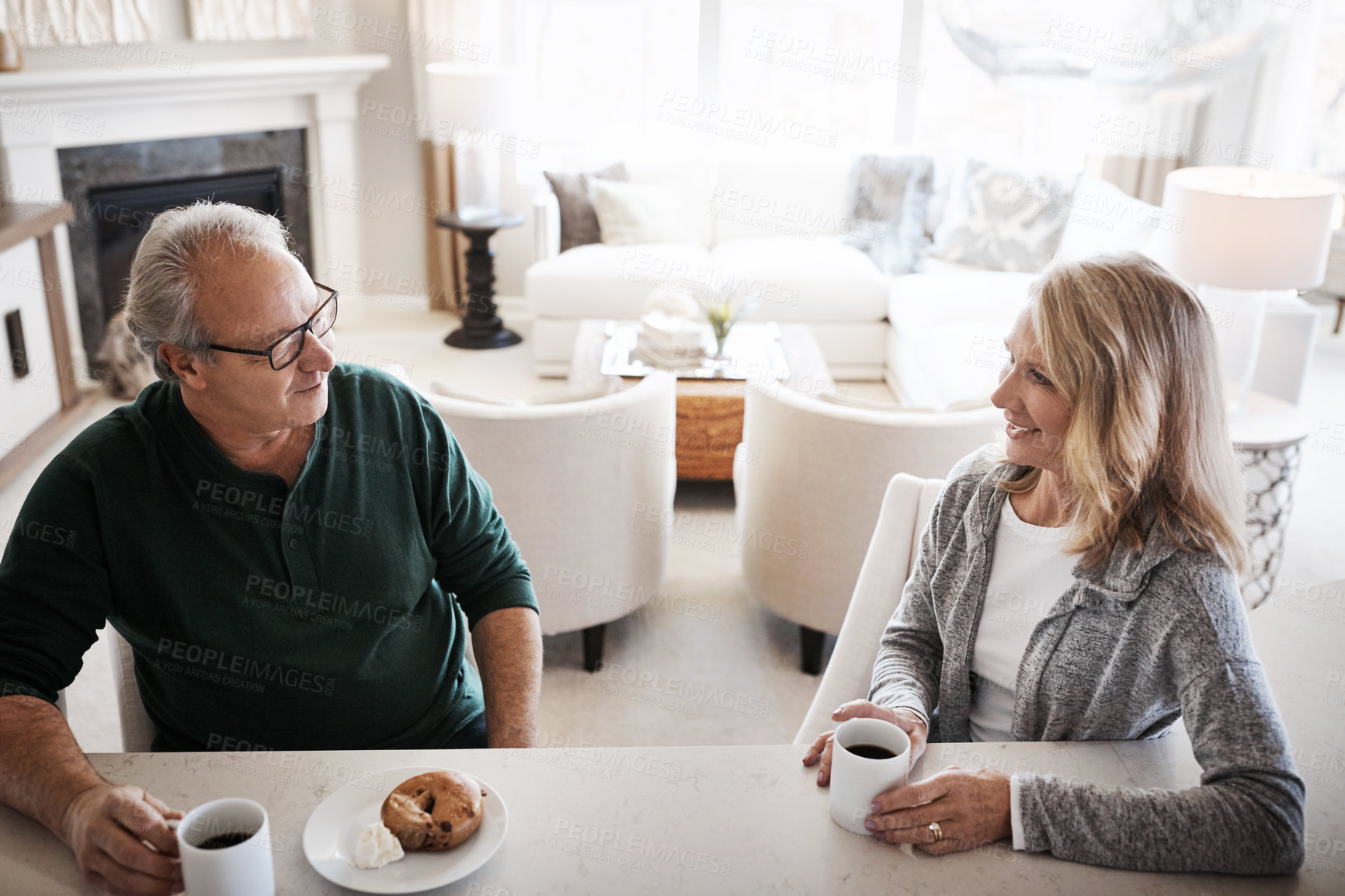 Buy stock photo Shot of a mature couple having coffee and a snack together during a relaxed day at home