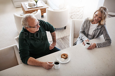 Buy stock photo Shot of a mature couple having coffee and a snack together during a relaxed day at home