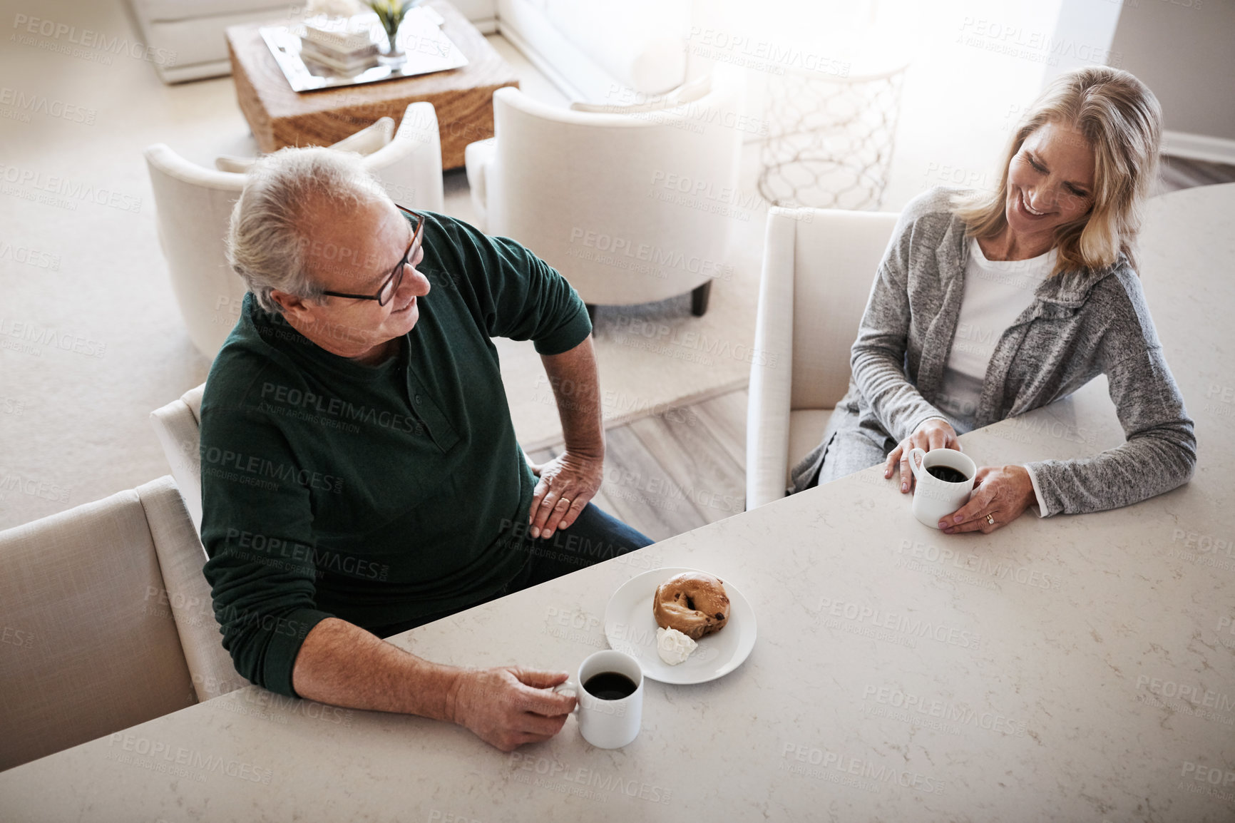 Buy stock photo Shot of a mature couple having coffee and a snack together during a relaxed day at home