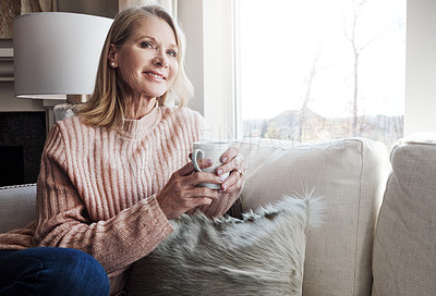 Buy stock photo Shot of a mature woman relaxing on the sofa at home with a cup of coffee